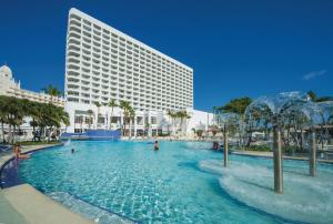 a swimming pool in front of a hotel at Riu Palace Antillas - Adults Only - All Inclusive in Palm-Eagle Beach