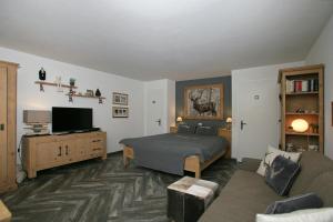 - une chambre avec un lit et un salon dans l'établissement Apartments Haus Quelle, à Loèche-les-Bains