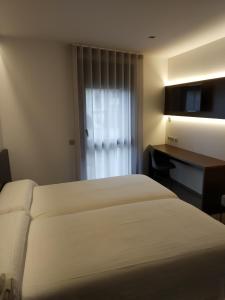 Un pat sau paturi într-o cameră la Hotel Olot Centre