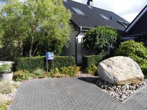 a house with a parking sign and a large rock at Appartement auf dem Land in Neuenkirchen