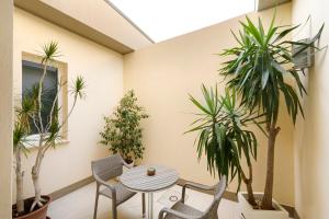 a room with a table and chairs and plants at Hotel La Villa Del Mare in Cagliari