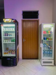 una puerta en un refrigerador junto a un refrigerador congelador en Poupahotel, en Taubaté