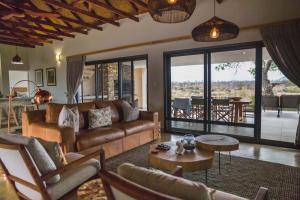 a living room with a couch and a table at Manzini River House in Hectorspruit