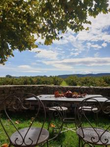 una mesa con dos sillas y una mesa con comida. en Domaine de Sévanes, en Saint-Paul-les-Fonts