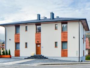 een wit huis met een zwart dak bij Apartamenty Szarotka in Wisła