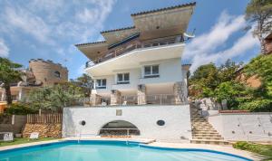 a house with a swimming pool in front of a building at TarracoHomes, Th128 Villa con vistas a la playa la Mora in Tarragona