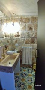 a bathroom with a sink and a stone wall at My Monopoli - Casa dei Fiori Suite "Mimosa" Casa d'epoca in Monopoli