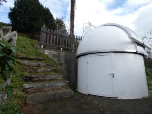 un cobertizo blanco con cúpula sentado junto a una valla en El Observatoriu, en Muñás