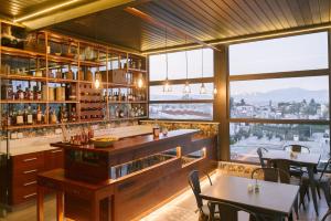 a restaurant with a bar with tables and windows at Hypnos Boutique Hotel in Nicosia