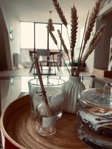 une table avec deux bocaux en verre et un vase avec des bâtons dans l'établissement Lichtrijke loft bij restaurant Den Olifant, à Ypres
