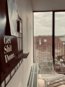 a sign that says get sit down on a window at Lichtrijke loft bij restaurant Den Olifant in Ieper