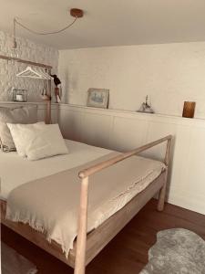 een slaapkamer met een bed met een houten frame bij Lichtrijke loft bij restaurant Den Olifant in Ieper