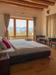 a large bed in a room with a large window at Heschuk Guest House in Leh