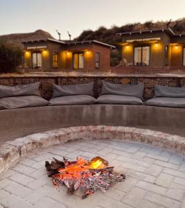 a fire pit in a backyard with a couch at Eco Karoo Mountain Lodge in Luckhoff