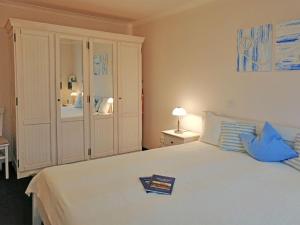 キュールングスボルンにあるResidenz-Ostseestrand-Wohnung-22-409のベッドルーム(青い枕の大きな白いベッド付)