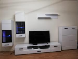 a living room with a white entertainment center with a flat screen tv at Fort Noks first line top seaview in Sveti Vlas