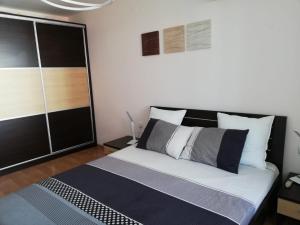 1 dormitorio con 1 cama grande con almohadas blancas y negras en Fort Noks first line top seaview en Sveti Vlas
