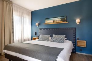 a bedroom with a large bed and a large window at Hôtel Restaurant Arcalod in Doussard