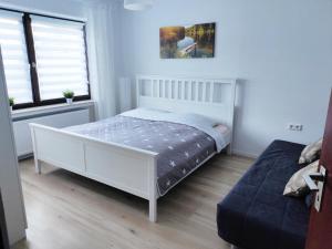 a white bedroom with a bed and a window at Ferienwohnung am Teutoburger Wald 1 in Oerlinghausen