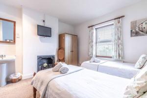 a bedroom with two beds and a tv and a fireplace at 4 Bed 3 Baths in CENTRAL WINDSOR! WALK 2 ALL THE SIGHTS! LEGOLAND 5 MIN DRIVE in Windsor