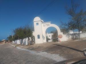 a white building with an arch in front of it at Porto Canoa Apartamento in Aracati