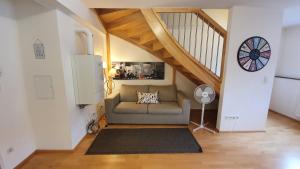 a living room with a couch and a staircase at Wiener Maisonette mit Terrasse in Vienna