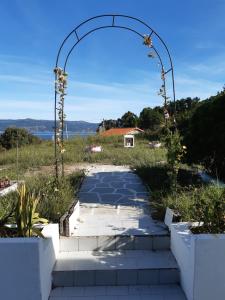 an arch over a walkway in a garden at Casa Montelouro in Muros