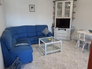 Casa Montelouro في موروس: غرفة معيشة مع أريكة زرقاء وطاولة