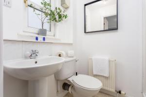 a white bathroom with a sink and a toilet at Millbrae Residence - Donnini Apartments in Ayr +13 photos