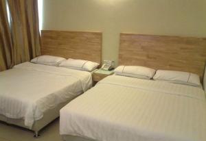 a hotel room with two beds and a telephone between them at Hotel Desaria in Petaling Jaya