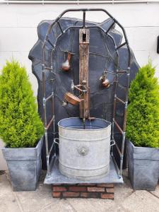 een fontein in een metalen structuur met twee planten bij The Labouring Man in Coldwaltham