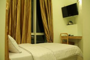 a bedroom with a bed and a window with a television at Hotel Desaria in Petaling Jaya