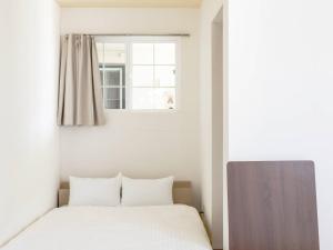 1 dormitorio con cama y ventana en Bluebird Hotel en Fujikawaguchiko