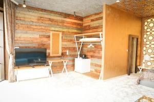 a room with a wooden wall with a television and a table at VIP House Glavatarski Han in Glavatartsi