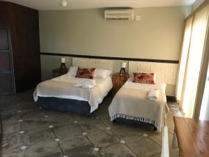 a bedroom with two beds and a table at Komati Kruger Villas in Komatipoort +17 photos