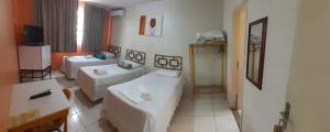 una camera d'albergo con due letti e una televisione di Hotel Itaipu a Goiânia