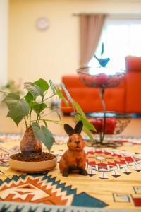 a table with a rabbit and two potted plants on it at Baan Rub Lom by Jane in Pak Chong