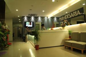 two people standing at a counter in a store at Hotel Desaria in Petaling Jaya