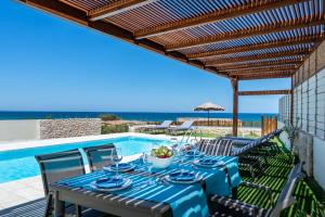 a table with a blue table cloth on a patio at Lux Villa Nymphes Dioni, 30m from beach with Pool, BBQ and Play Area in Stavromenos