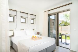 a white bedroom with a bed and a balcony at Lux Villa Nymphes Dioni, 30m from beach with Pool, BBQ and Play Area in Stavromenos +31 photos