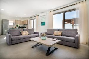 a living room with two couches and a coffee table at Lux Villa Nymphes Dioni, 30m from beach with Pool, BBQ and Play Area in Stavromenos