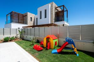 a house with a playground in front of it at Lux Villa Nymphes Dioni, 30m from beach with Pool, BBQ and Play Area in Stavromenos