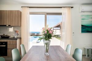 a vase of flowers on a wooden table in a kitchen at Lux Villa Nymphes Dioni, 30m from beach with Pool, BBQ and Play Area in Stavromenos