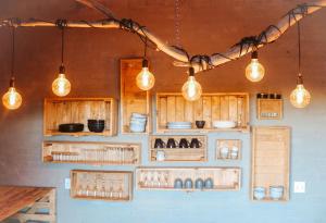 a kitchen with wooden cabinets and lights on the wall at Eco Karoo Mountain Lodge in Luckhoff