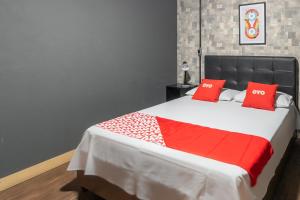 um quarto com uma cama com almofadas vermelhas em OYO Hotel Massimo Brooklin, Sao Paulo em São Paulo