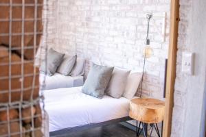 um sofá branco num quarto com uma parede de tijolos em Eco Karoo Mountain Lodge em Luckhoff