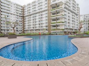 a swimming pool in front of a large apartment building at RedLiving Apartemen Gateway Pasteur - TN Hospitality 1 Tower Jade B in Bandung