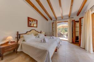 a bedroom with two beds and a large window at Villa Vall Den March II in Pollença +43 photos