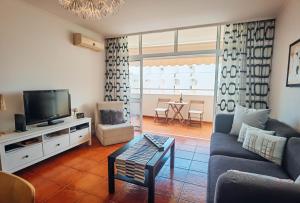 a living room with a couch and a tv at Apartment Rocha Varandas Orquídea in Portimão