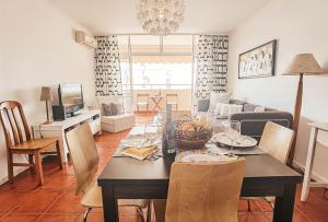 a dining room and living room with a table and chairs at Apartment Rocha Varandas Orquídea in Portimão